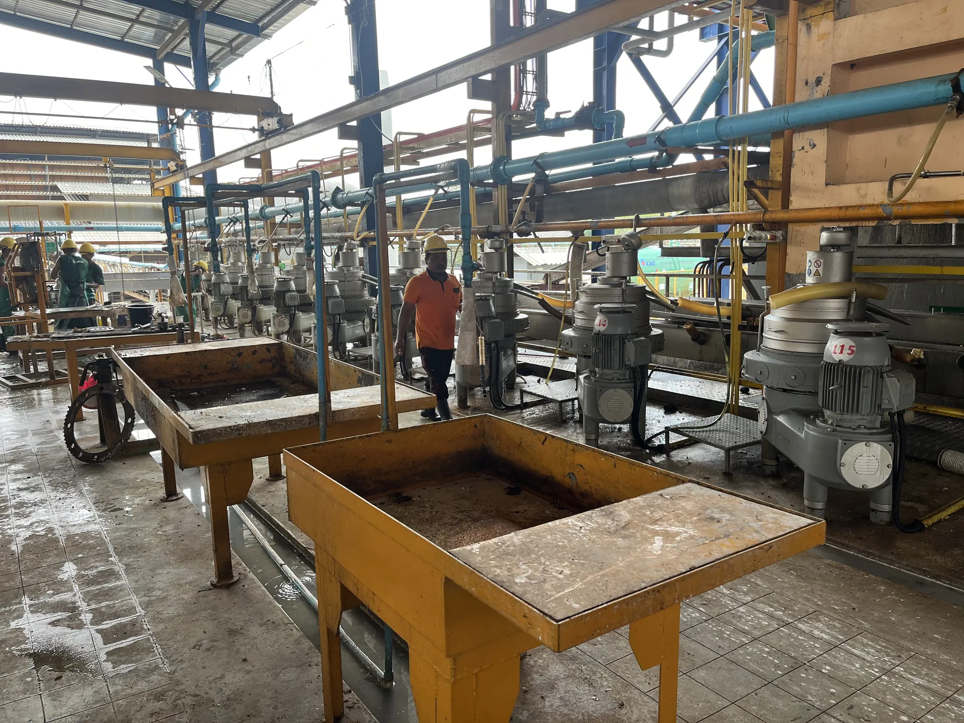 Worker among latex centrifuge separators on the production floor