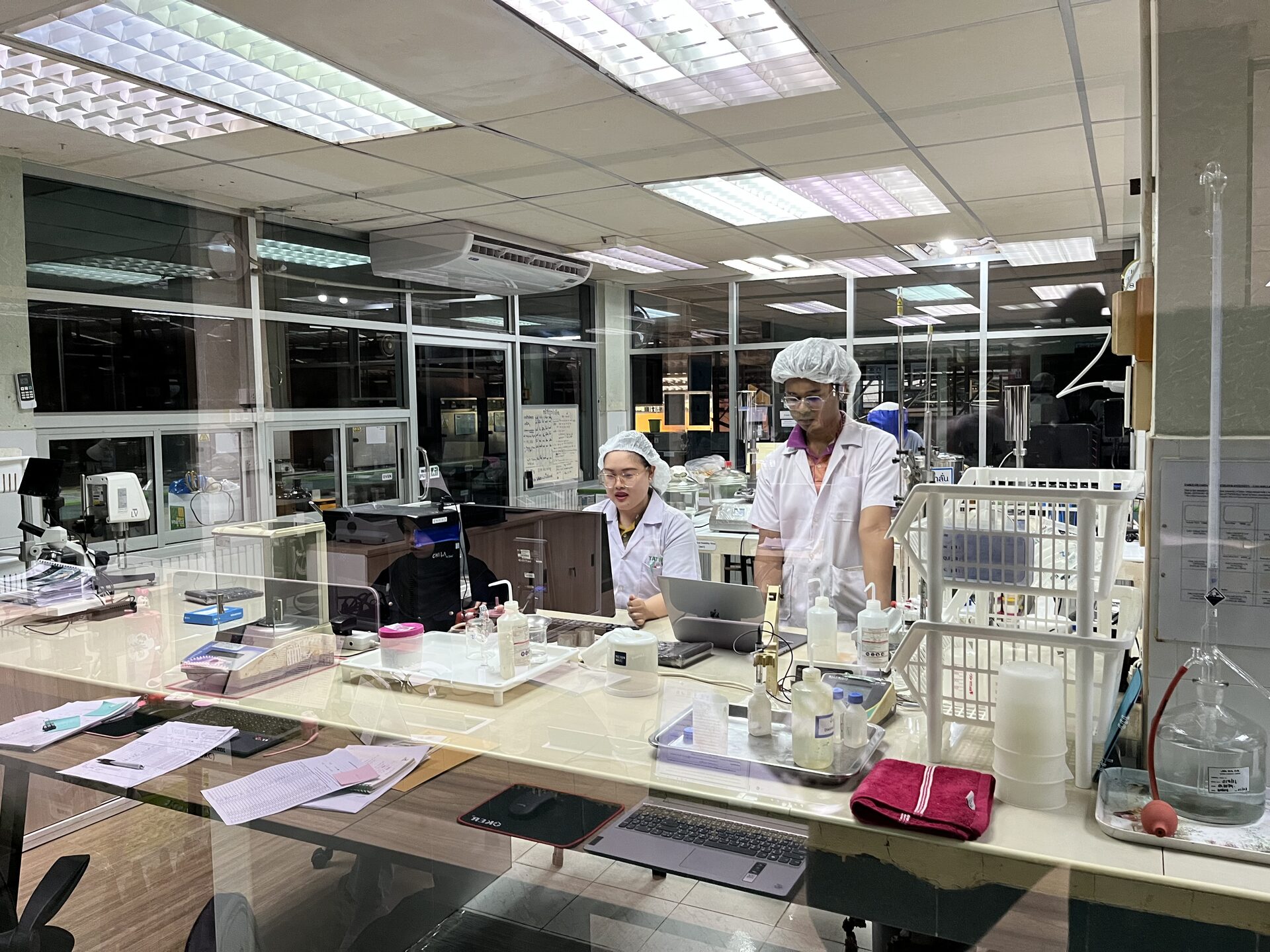 Two quality-control technicians testing latex samples in the Tat Win lab