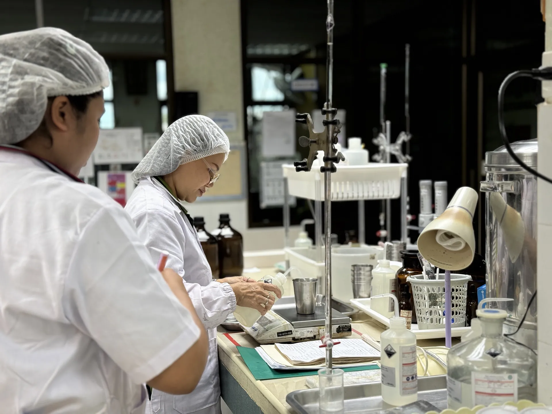 Tat Win QC technicians running a titration at the lab bench